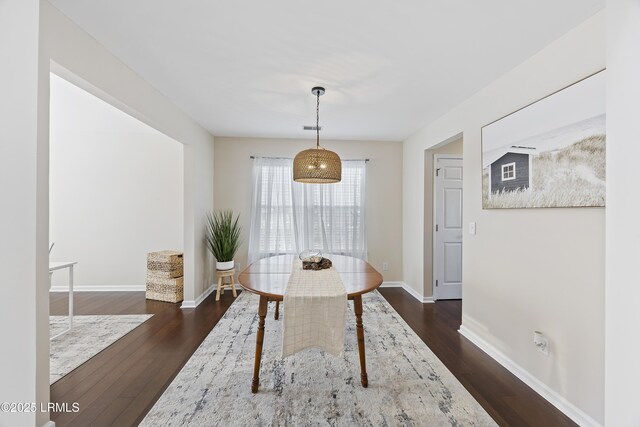 dining space featuring baseboards and dark wood-type flooring