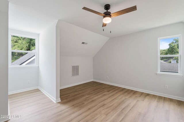 additional living space with lofted ceiling, a healthy amount of sunlight, and light hardwood / wood-style floors