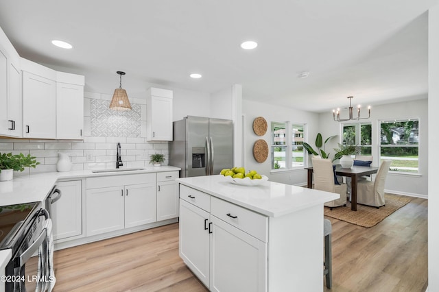 kitchen featuring white cabinetry, appliances with stainless steel finishes, sink, and pendant lighting