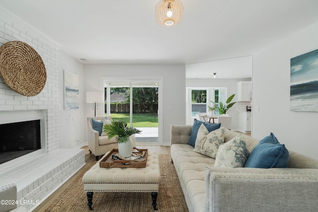 living room featuring hardwood / wood-style flooring and a brick fireplace