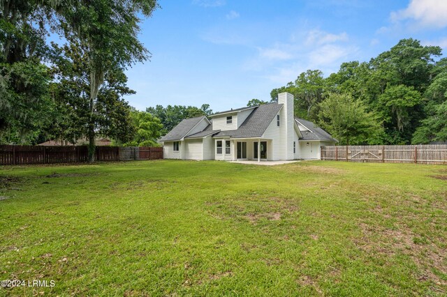 rear view of house with a yard and a patio area