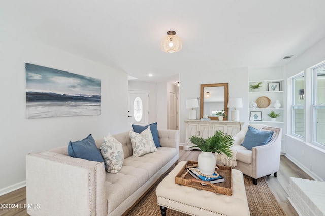 living room with hardwood / wood-style floors and built in features