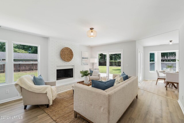 living room with a fireplace and light wood-type flooring