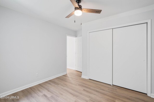 unfurnished bedroom with light hardwood / wood-style floors, a closet, and ceiling fan