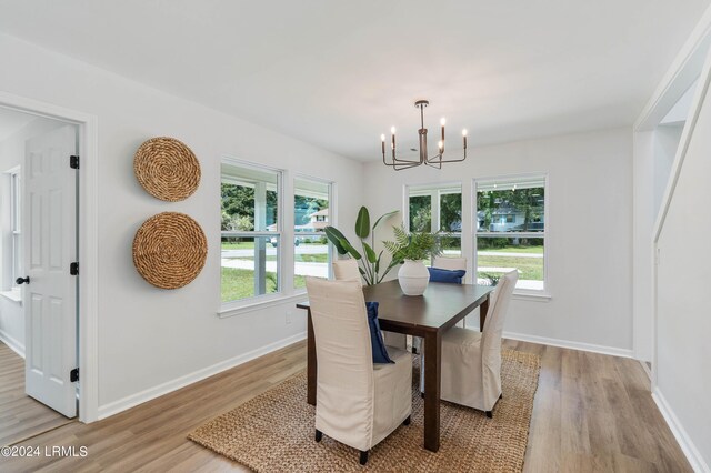 dining space with an inviting chandelier and light hardwood / wood-style flooring