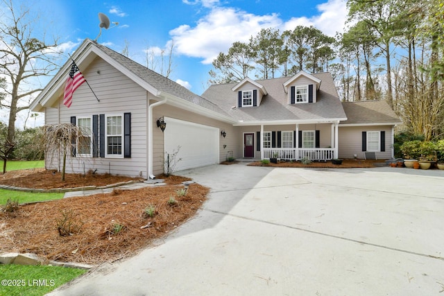 cape cod-style house featuring covered porch, roof with shingles, an attached garage, and concrete driveway