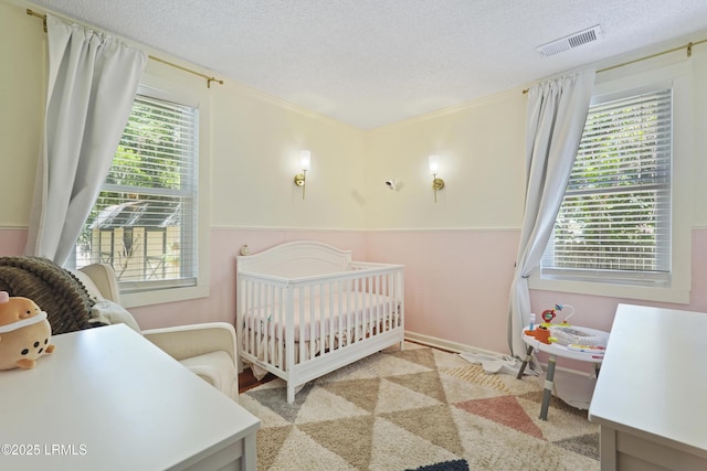 174 James St, Beaufort, SC 29902 - bedroom featuring a crib and a textured ceiling