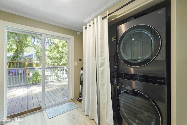 174 James St, Beaufort, SC 29902 - washroom featuring stacked washer and clothes dryer, wood finished floors, a textured ceiling, and crown molding