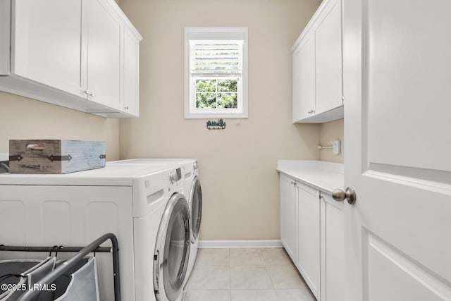 clothes washing area featuring light tile patterned floors, baseboards, independent washer and dryer, and cabinet space