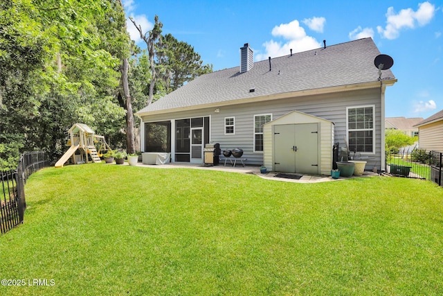 back of property with a fenced backyard, a yard, and a chimney