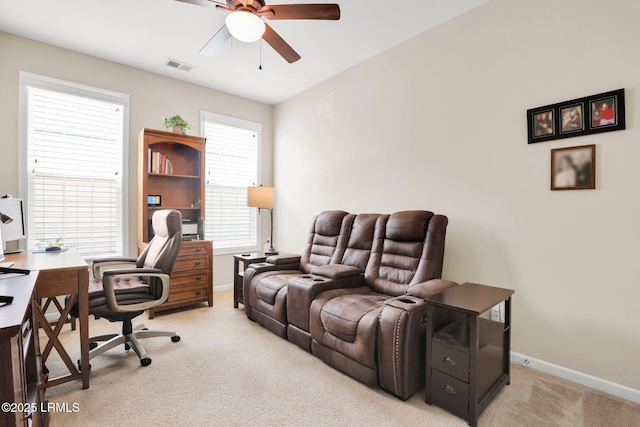 carpeted home office with baseboards, ceiling fan, and visible vents