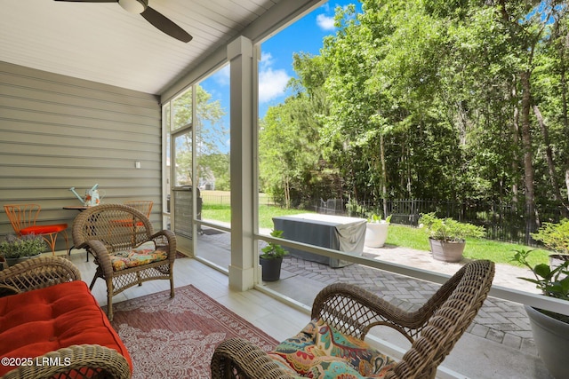 sunroom / solarium featuring a ceiling fan