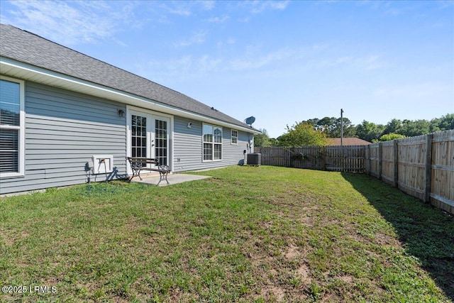 view of yard with central AC unit, french doors, and a patio area