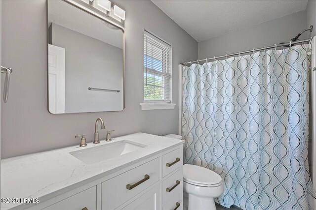 full bath with toilet, a textured ceiling, vanity, and curtained shower