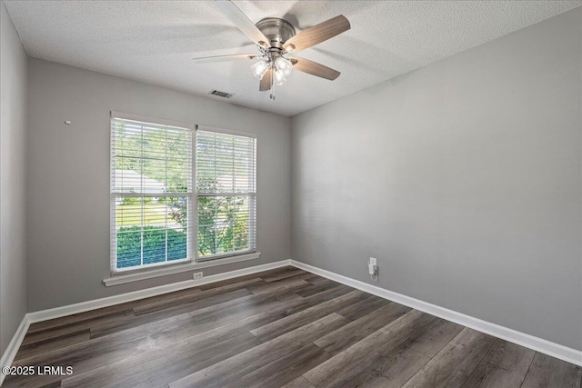 spare room featuring dark wood-style flooring, a textured ceiling, baseboards, and a ceiling fan