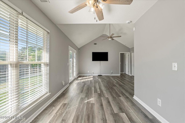 unfurnished living room with a ceiling fan, wood finished floors, baseboards, and vaulted ceiling