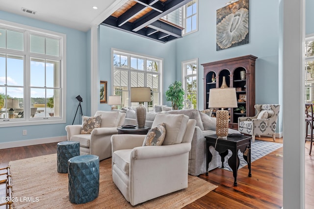 70 Brams Point Rd, Hilton Head Island, SC 29926 - living room featuring plenty of natural light, wood finished floors, a towering ceiling, and baseboards