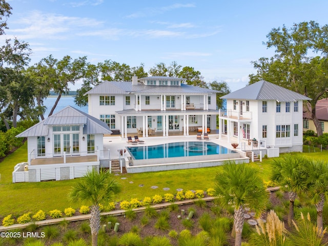 70 Brams Point Rd, Hilton Head Island, SC 29926 - rear view of property featuring a balcony, a lawn, a patio, an outdoor pool, and a standing seam roof