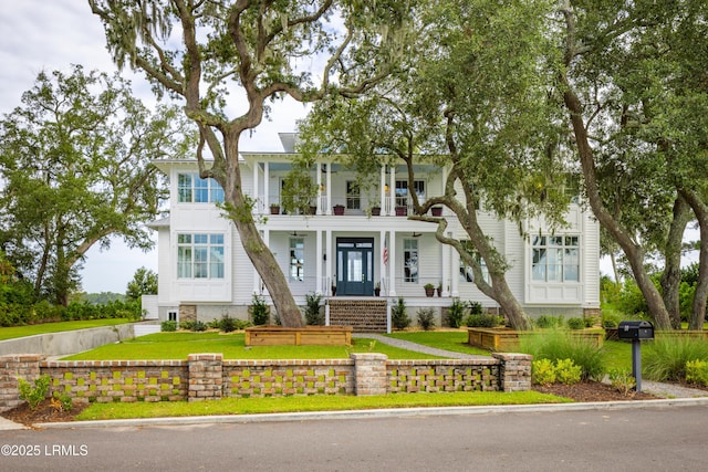 70 Brams Point Rd, Hilton Head Island, SC 29926 - view of front facade with a balcony, a front yard, and asphalt driveway