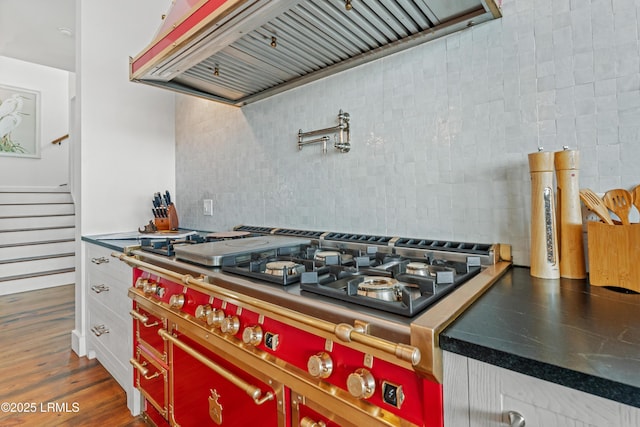 70 Brams Point Rd, Hilton Head Island, SC 29926 - kitchen view of premium range hood, stainless steel gas stovetop, pot filler, tasteful backsplash, and white cabinetry