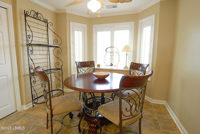 dining area with ceiling fan, baseboards, visible vents, ornamental molding, and stone tile flooring
