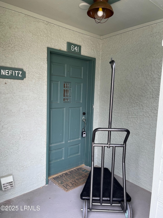 property entrance featuring stucco siding and ceiling fan