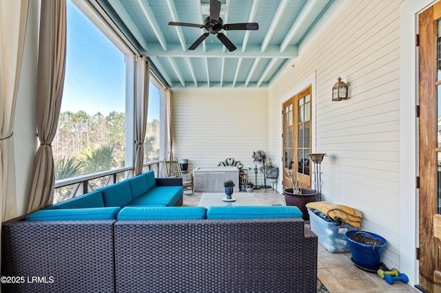 sunroom / solarium featuring a ceiling fan and beamed ceiling