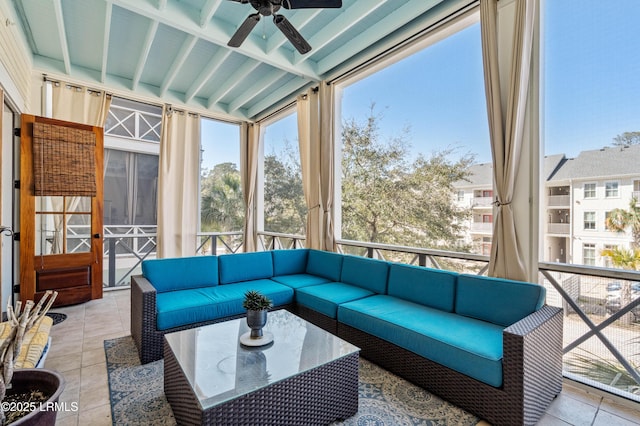 sunroom with a ceiling fan and beam ceiling