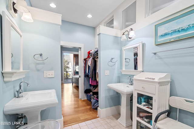 bathroom featuring tile patterned flooring, a sink, baseboards, and recessed lighting