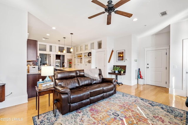 living area with light wood-type flooring, visible vents, a ceiling fan, and recessed lighting