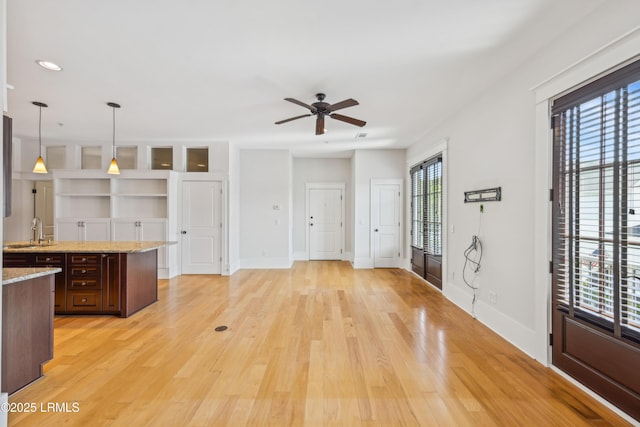 6 Abbey Row Unit 2A, Beaufort, SC 29906 - kitchen featuring a sink, decorative light fixtures, light wood-type flooring, a ceiling fan, and baseboards
