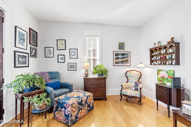 living area with baseboards and wood finished floors