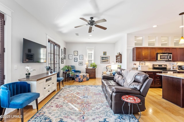 living room featuring a ceiling fan, recessed lighting, and light wood-style flooring