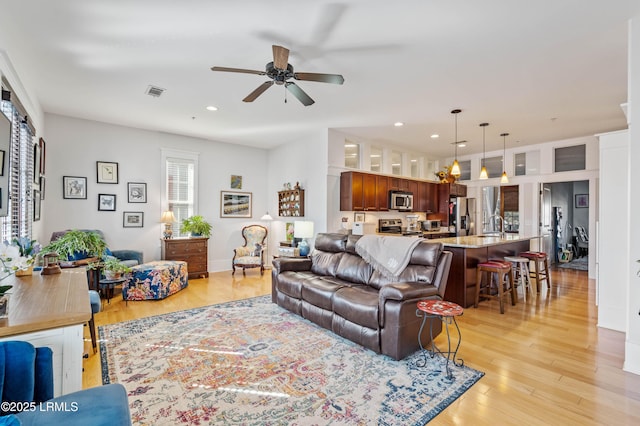 living area with visible vents, a ceiling fan, light wood-style flooring, and recessed lighting