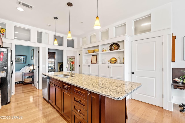 kitchen with a sink, visible vents, appliances with stainless steel finishes, light wood-type flooring, and decorative light fixtures