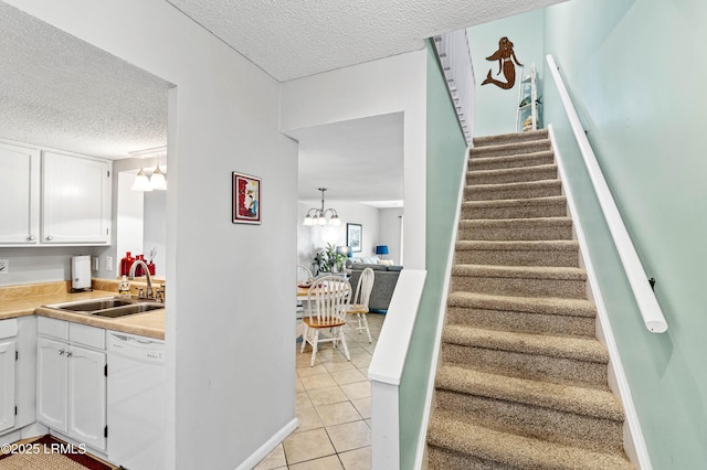 stairway featuring a textured ceiling, a chandelier, and tile patterned flooring