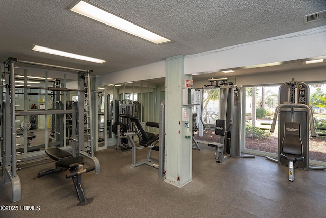 gym featuring visible vents and a textured ceiling