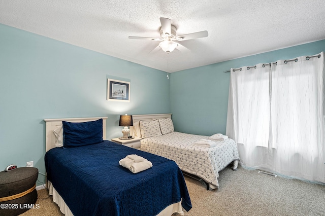 carpeted bedroom with a ceiling fan, a textured ceiling, and visible vents