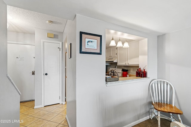 interior space featuring a textured ceiling and light tile patterned flooring