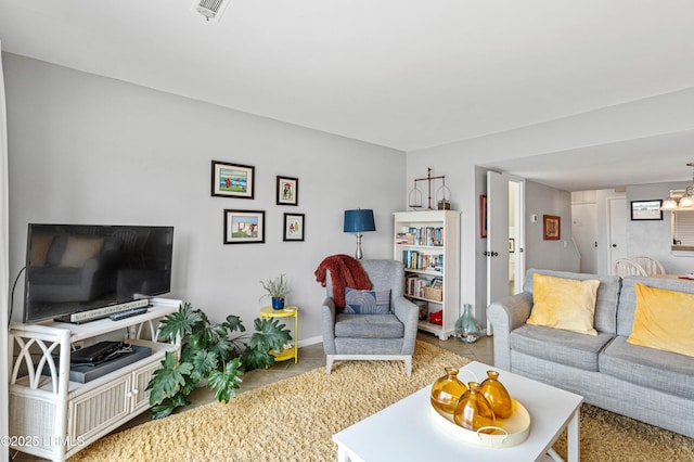 tiled living room featuring visible vents, baseboards, and a notable chandelier