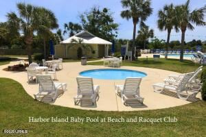 community pool with a patio and a lawn