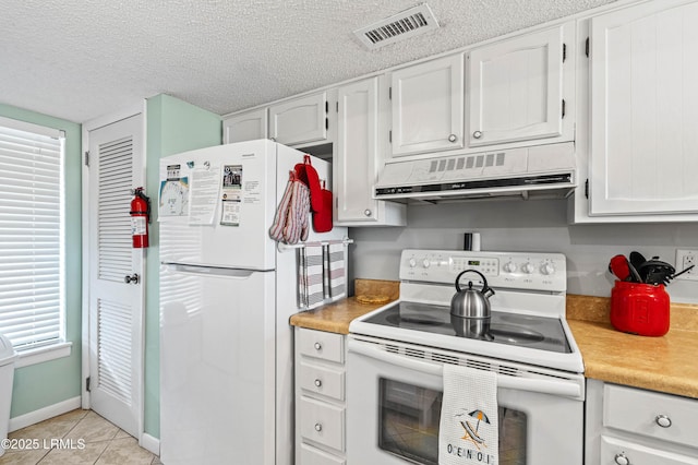 kitchen featuring light tile patterned flooring, ventilation hood, white appliances, light countertops, and visible vents