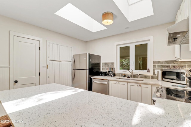 kitchen featuring stainless steel appliances, sink, white cabinets, and kitchen peninsula