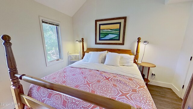 bedroom with wood-type flooring and vaulted ceiling