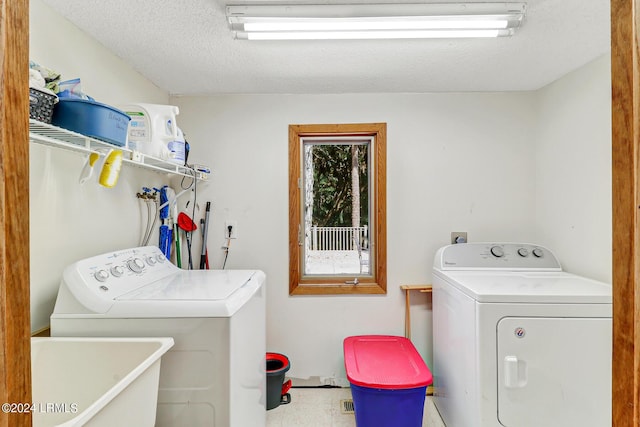 clothes washing area featuring independent washer and dryer, sink, and a textured ceiling