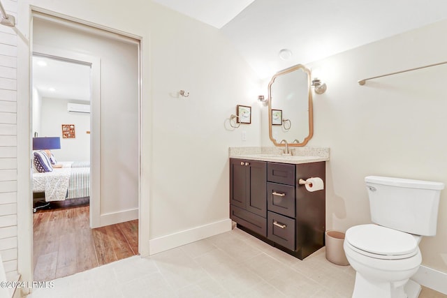 bathroom with vanity, tile patterned flooring, an AC wall unit, and toilet