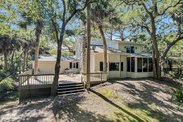 back of property with a deck and a sunroom