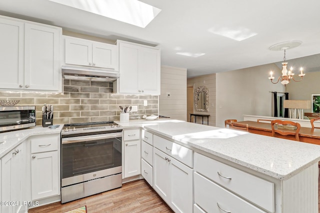 kitchen featuring stainless steel electric stove, decorative light fixtures, light wood-type flooring, and white cabinets