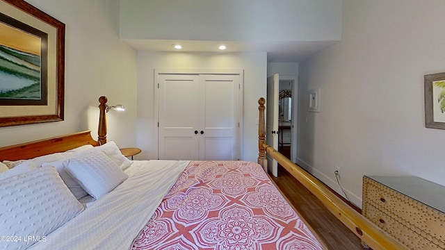 bedroom with dark wood-type flooring and a closet