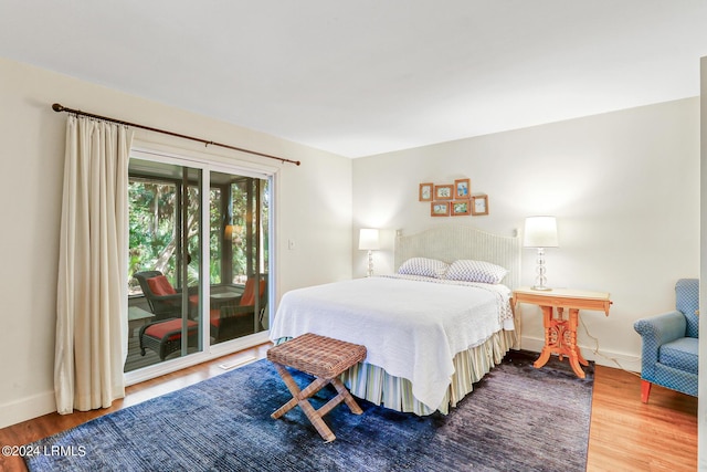 bedroom with wood-type flooring and access to outside